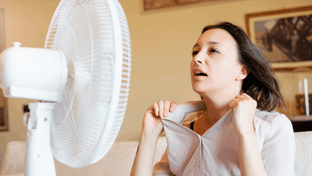 a woman sweats in front of a fan